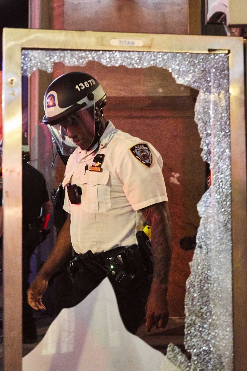 A police officer viewed through a shattered pane of glass