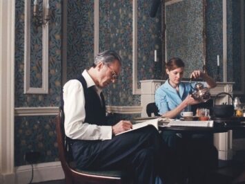 A man and woman sit at a desk in a still shot of the film Phantom Thread / Courtesy Focus Features
