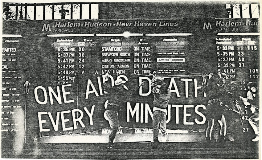 ACT UP activists hang a banner in Grand Central Terminal, reading "One AIDS death every 8 minutes."