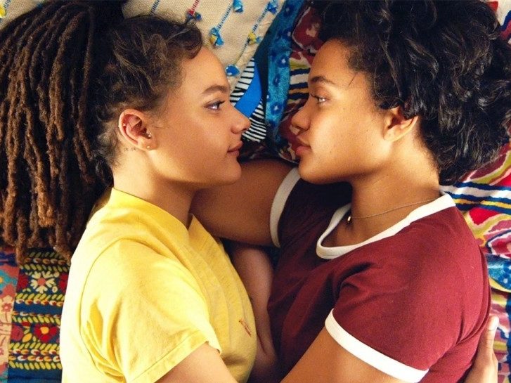 Two girls lie facing each other